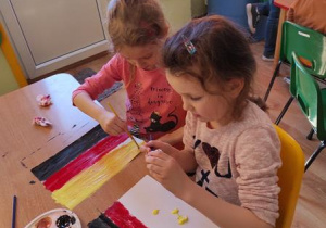 Ania i Zuzia K. malują flagę Niemiec.